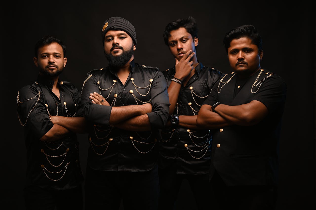 Dramatic portrait of four fashionable men posing in black outfits, Kolkata.